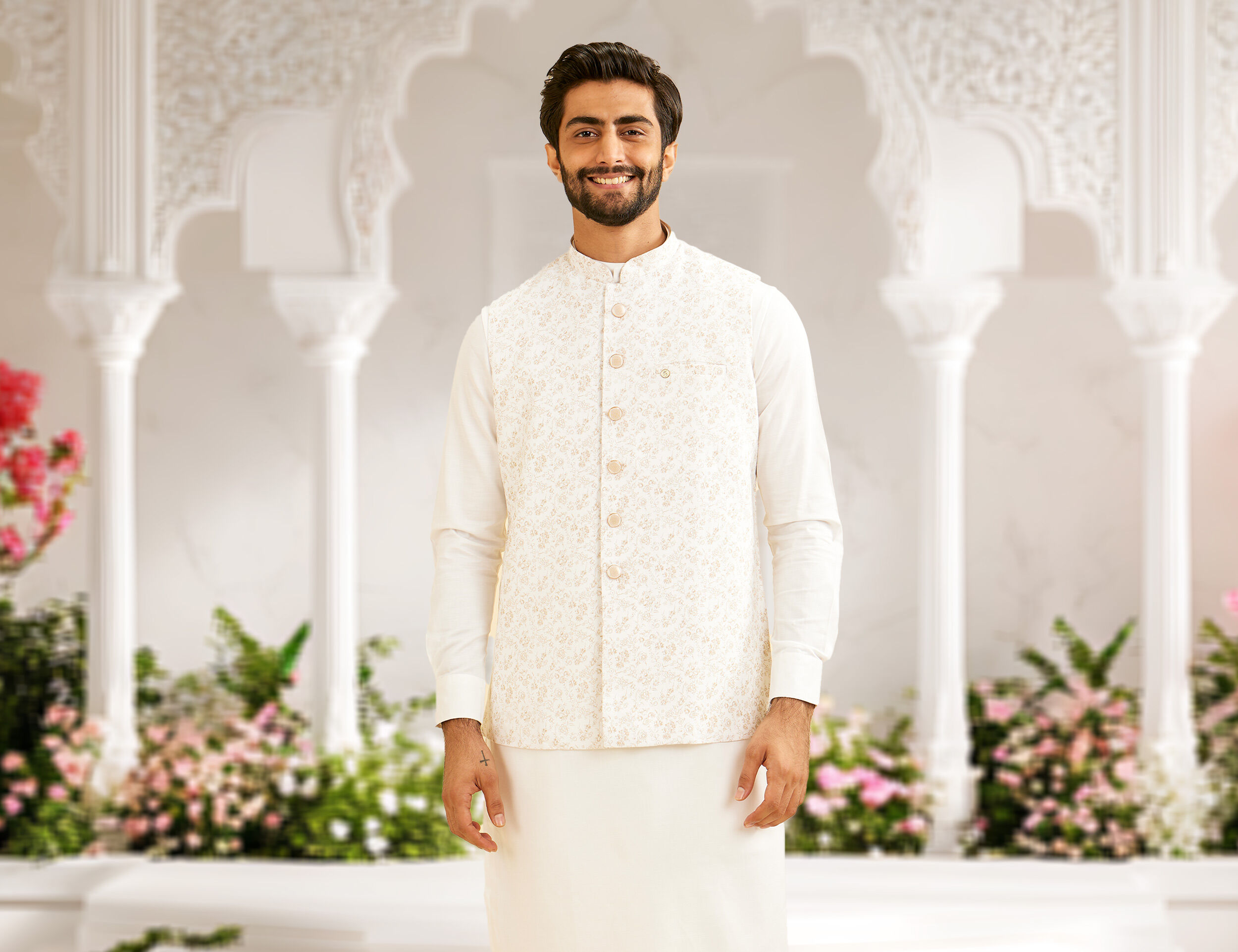 A man wearing a white bel buti nehru jacket for destination wedding